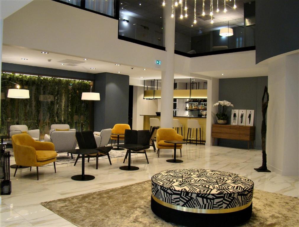 een lobby met stoelen en een tafel en aasteryasteryasteryasteryasteryasteryasteryasteryastery bij L'Amirauté Brest in Brest