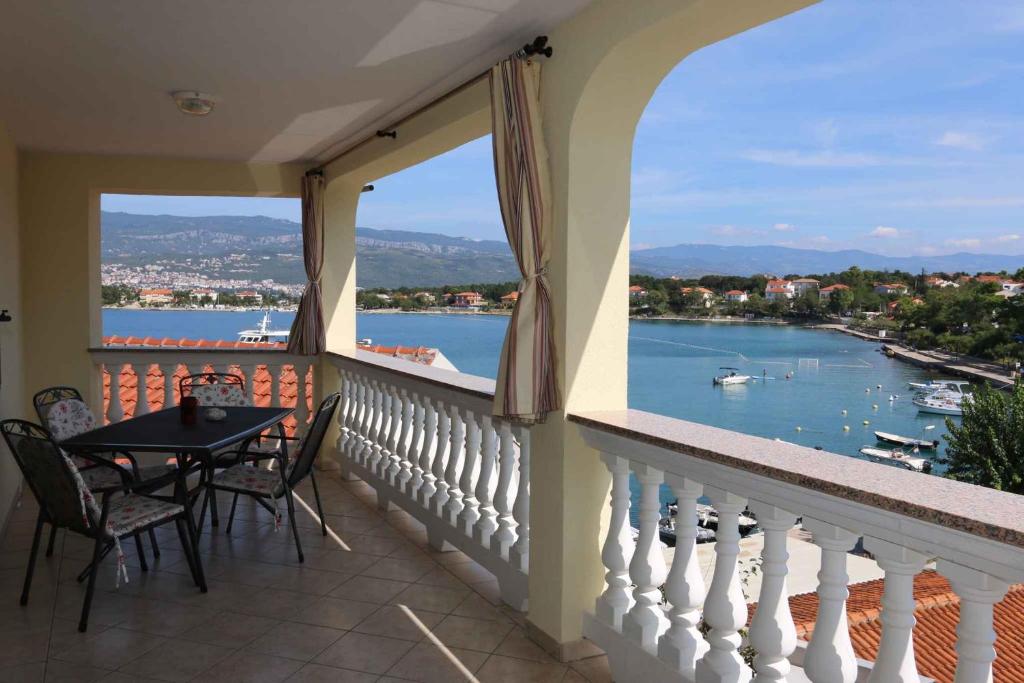 balkon ze stołem i krzesłami oraz widokiem na wodę w obiekcie Apartments in Silo - Insel Krk 13592 w mieście Šilo