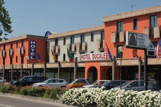 una strada con auto parcheggiate di fronte a un edificio di Hotel Residence Ducale a Porto Mantovano