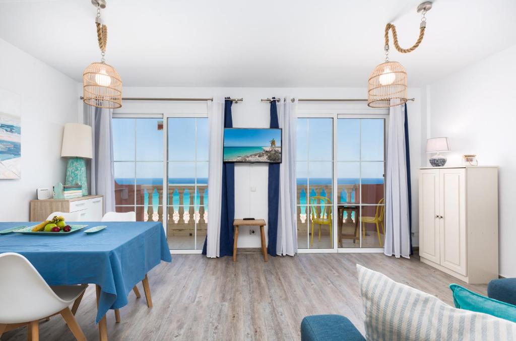 uma sala de estar com uma mesa azul e vistas para o oceano em Casa Wind em Costa Calma