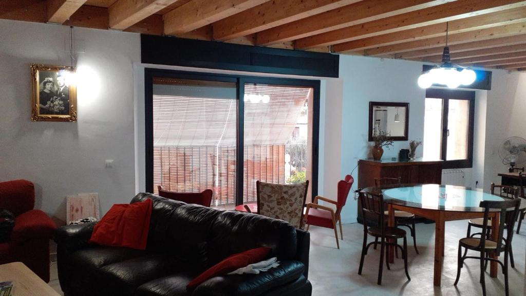 a living room with a black leather couch and a table at Cal Marquès in Cerviá