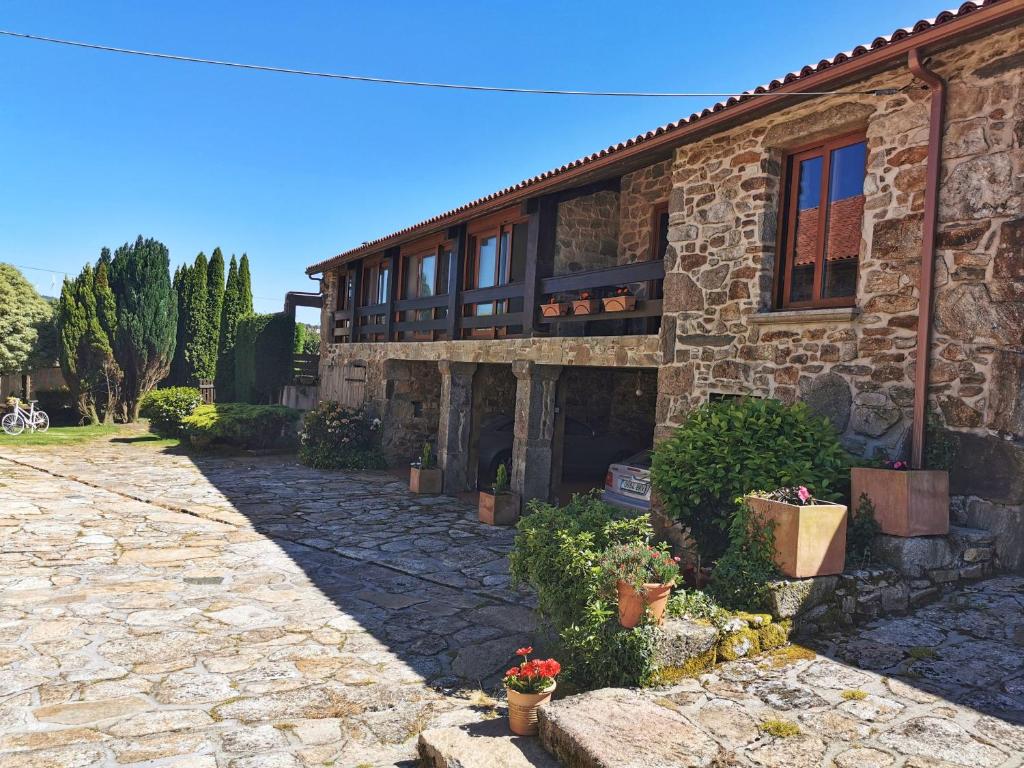 Apartamentos rurales Casa Gorrión - Mazaricos في Sanfoga: بيت حجري أمامه نباتات