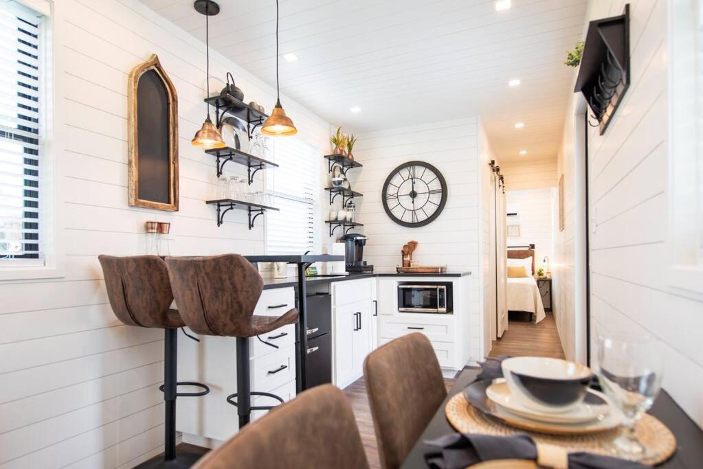 a kitchen and dining room with a table and chairs at The Newtonian Tiny Container Home near Magnolia in Bellmead