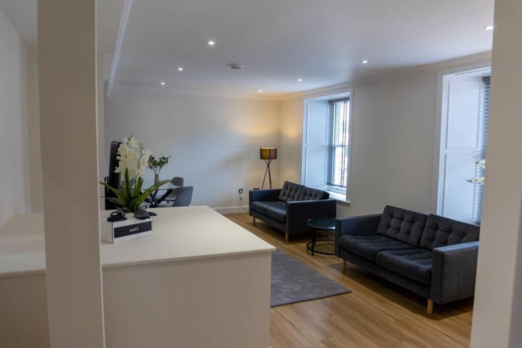 a living room with two couches and a table at Argyle Square Apartment in Oban