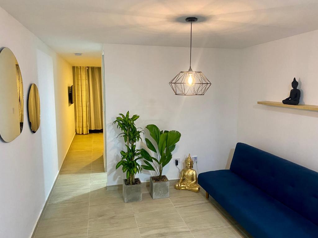 een woonkamer met een blauwe bank en planten bij Apartaesudio Copenhagen AXM in Armenia