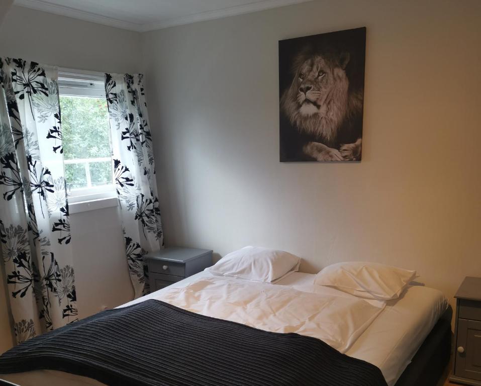 a bedroom with a bed with a lion picture on the wall at Utleiebolig Fannrem in Fannrem