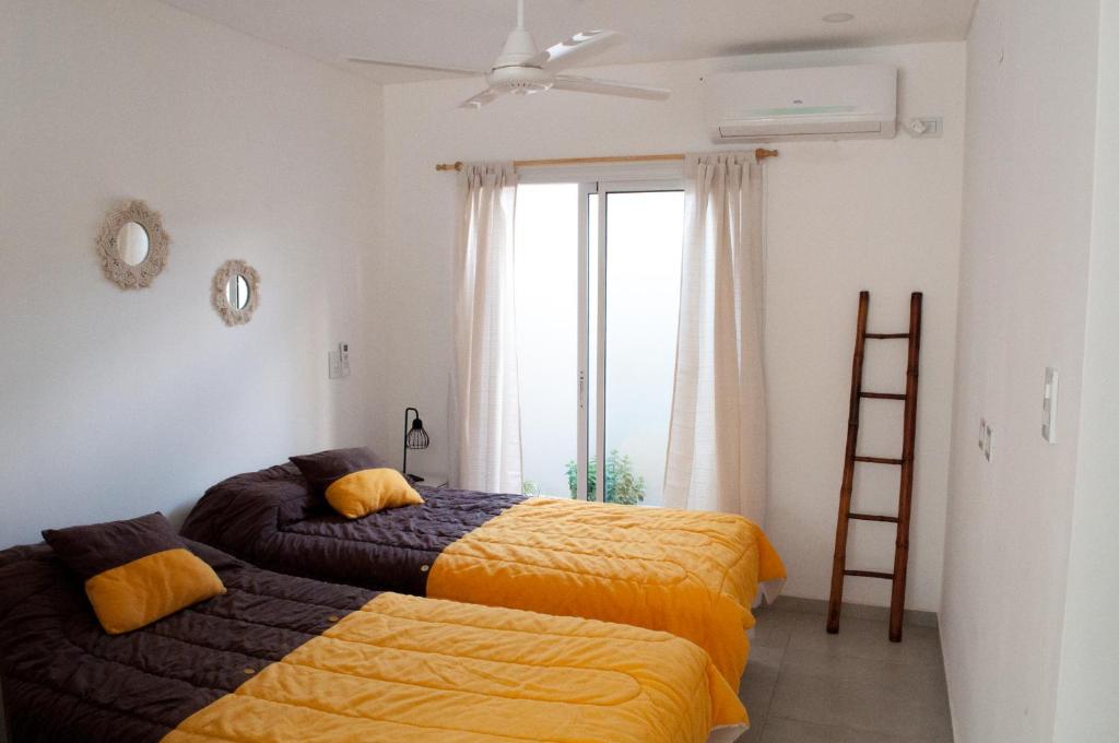 1 dormitorio con 2 camas, escalera y ventana en Mono ambiente amplio, luminoso y moderno con excelente ubicación en Rafaela