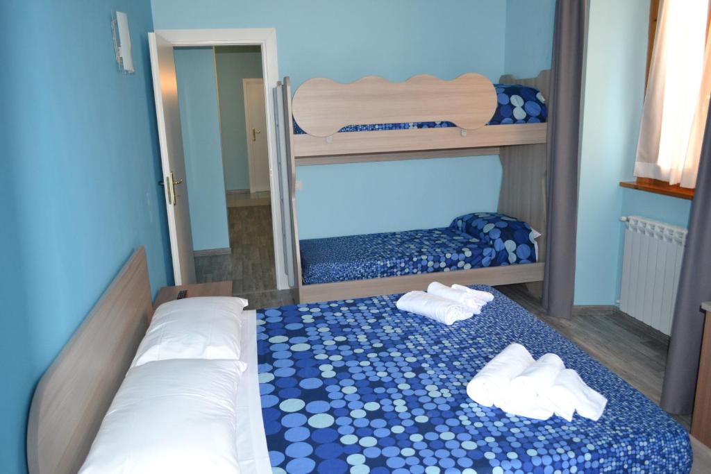 a bedroom with two bunk beds and two white shoes at B&B Porta Livorno in Civitavecchia