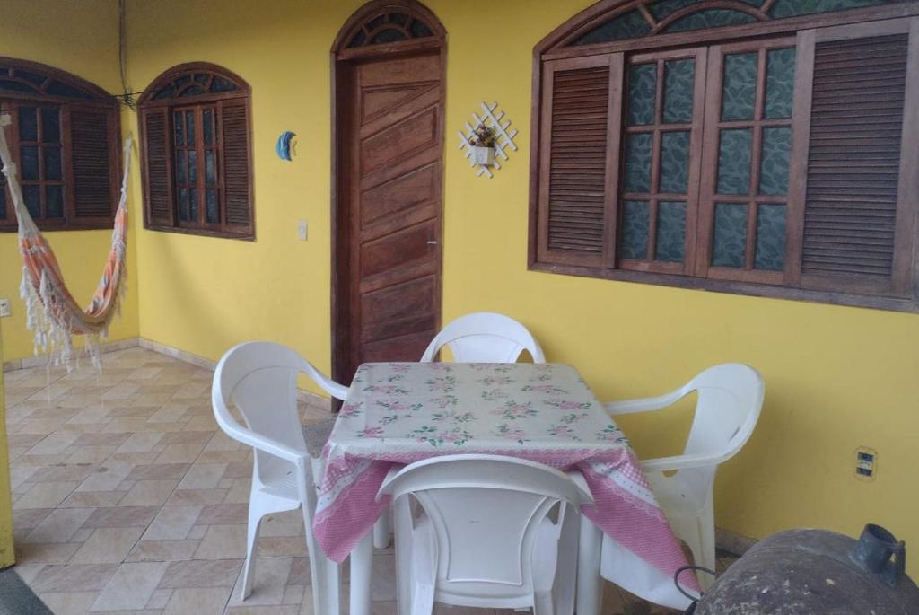 einen Tisch und Stühle in einem Zimmer mit gelber Wand in der Unterkunft Casa para temporada em Rio das Ostras in Rio das Ostras
