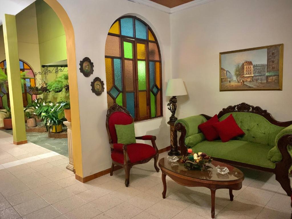 a living room with a couch and a table and stained glass at Casa Grande in Medellín