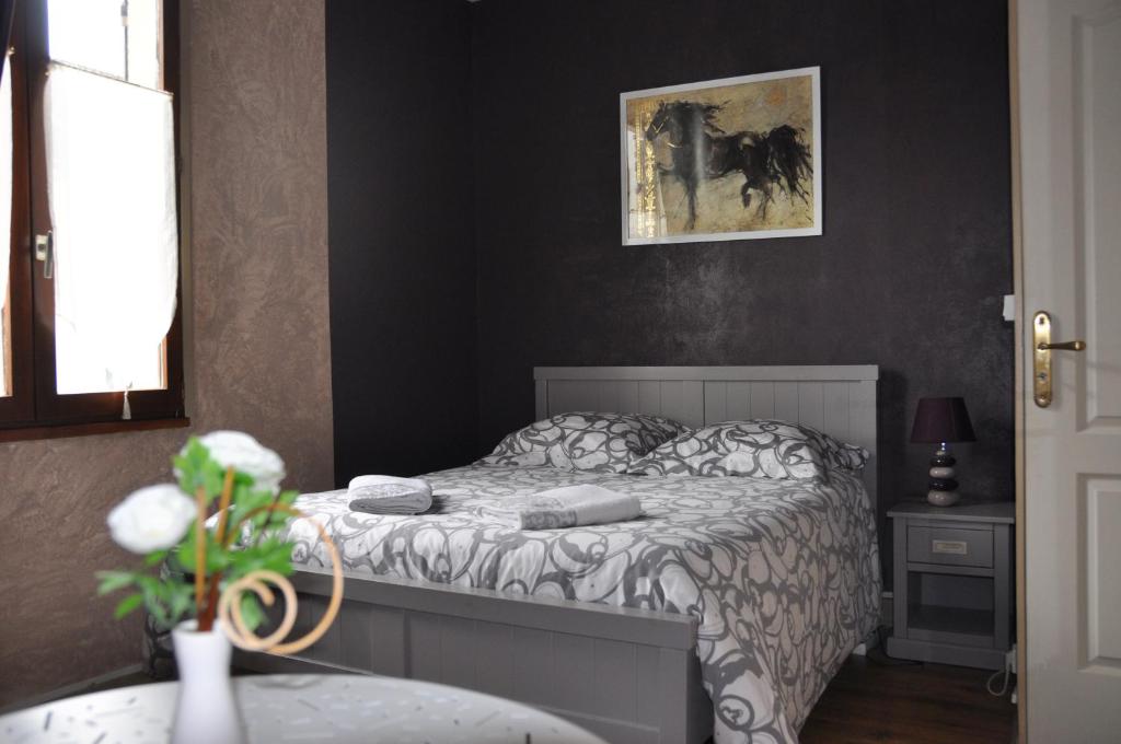 a bedroom with a bed and a picture on the wall at Chambres d'Hôtes L'Alezan in Orry-la-Ville