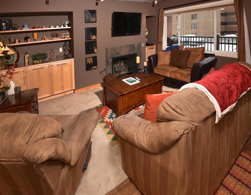 uma sala de estar com dois sofás e uma lareira em Vantage Point 101 Condo em Vail