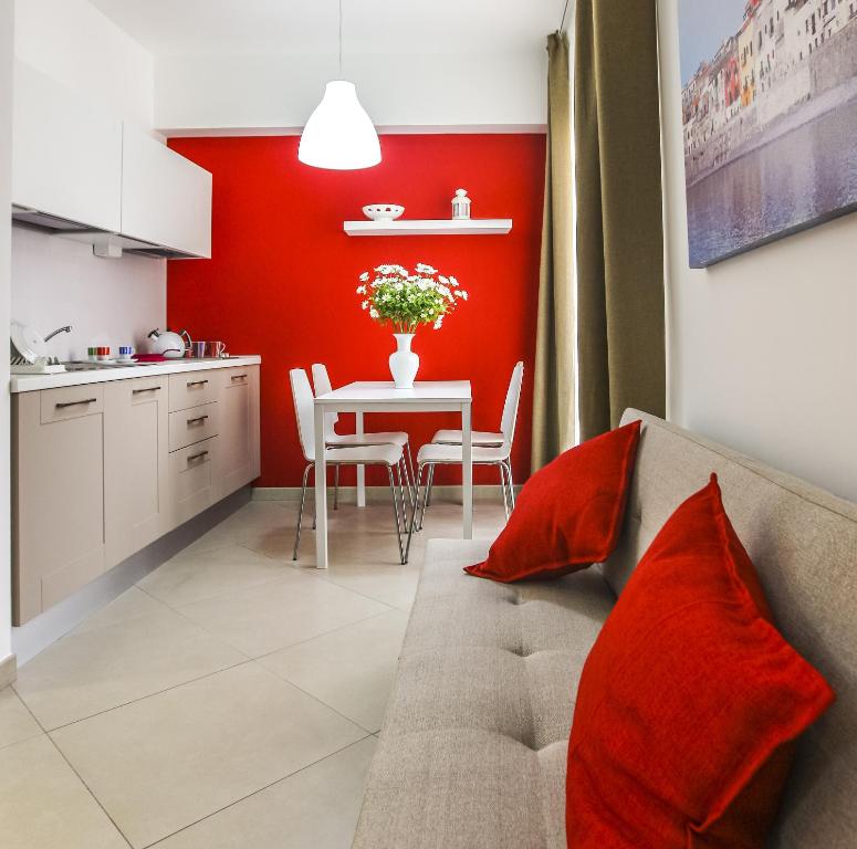 a kitchen and dining room with a red accent wall at Finestre d'Occidente in Trapani