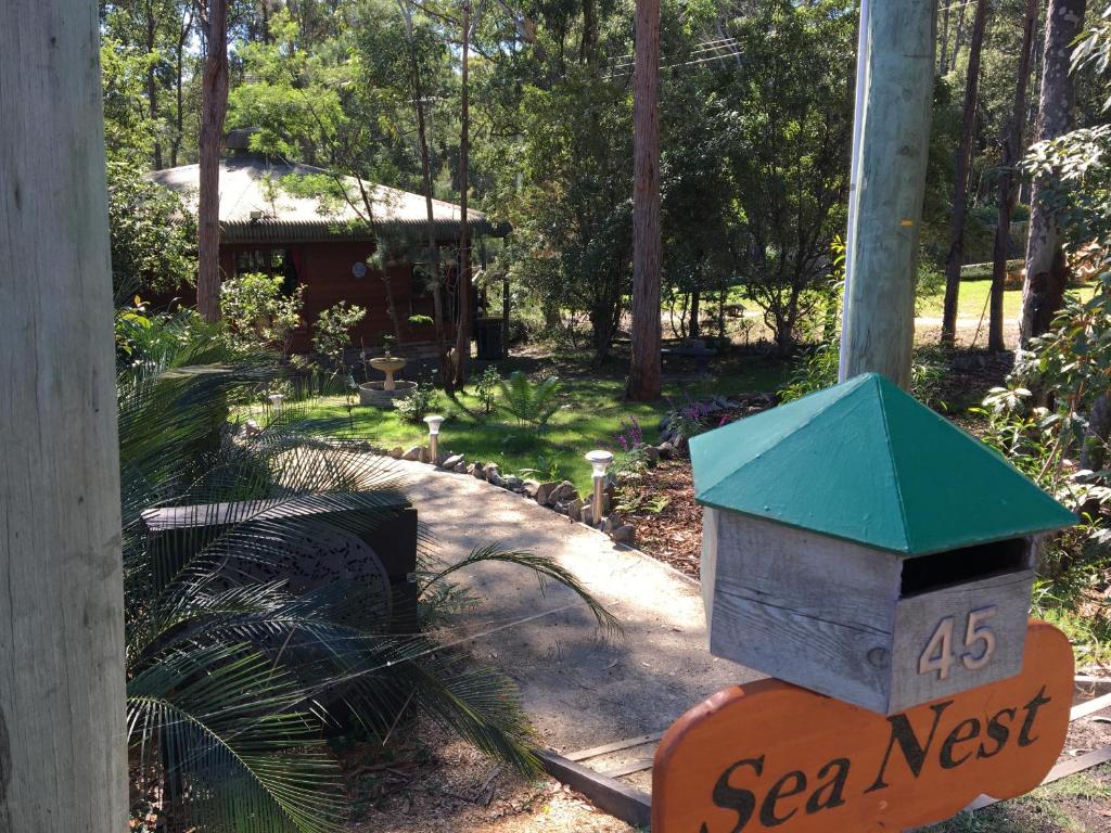 a bird house on a sign in a garden at Sea Nest in Batemans Bay