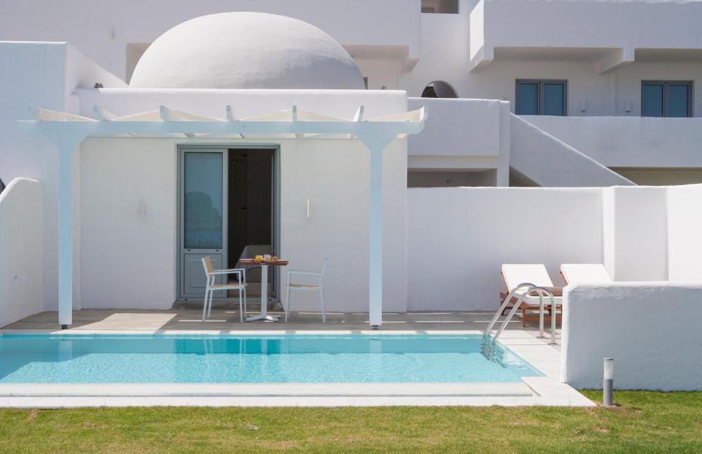 a villa with a swimming pool and a house at Lindos Sun Hotel in Líndos