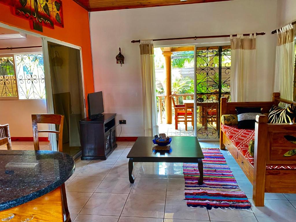 a living room with a table and a couch at Effie Mountain View coco villa in Mahe