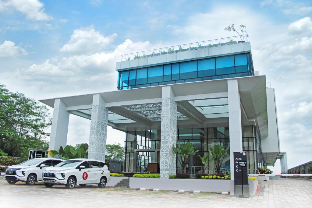 dos coches estacionados frente a un edificio en Braling Grand Hotel By Azana Purbalingga en Purbolinggo