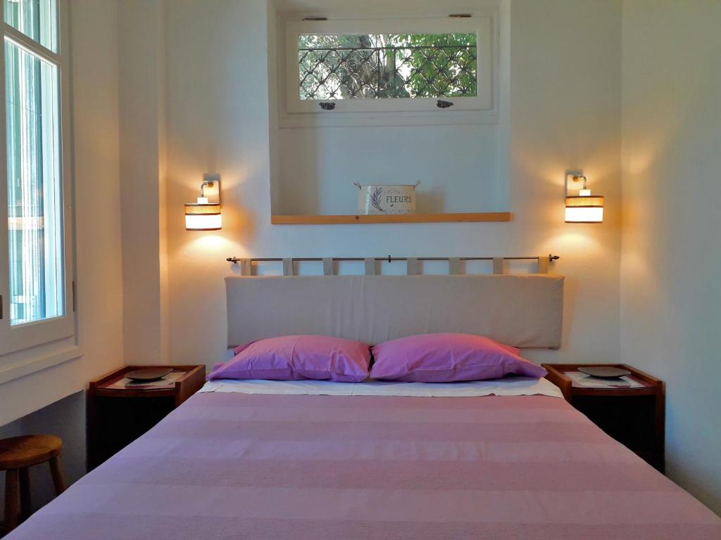 Un dormitorio con una cama con almohadas rosas y una ventana en Villetta in Verde! Magnificent sea view, en Akrotiri