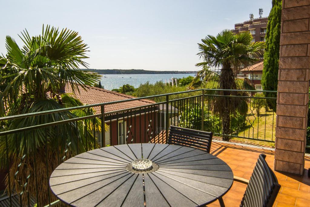 a table with an umbrella on a balcony at Apartments Sara 7, 8, 9 in Portorož