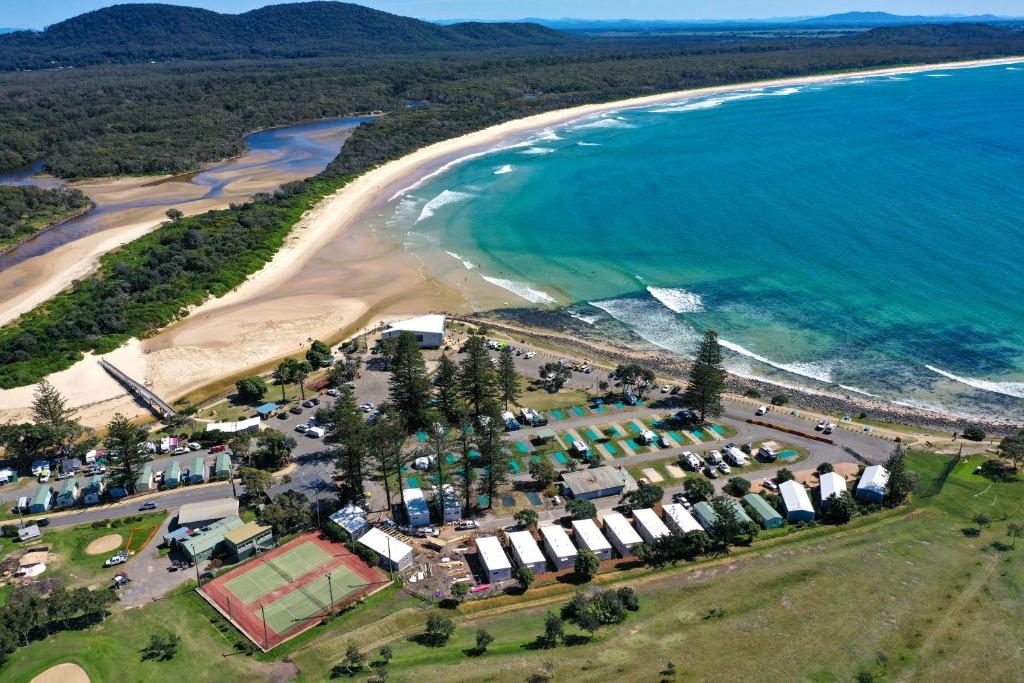 an aerial view of a beach and the ocean at Crescent Head Holiday Park in Crescent Head