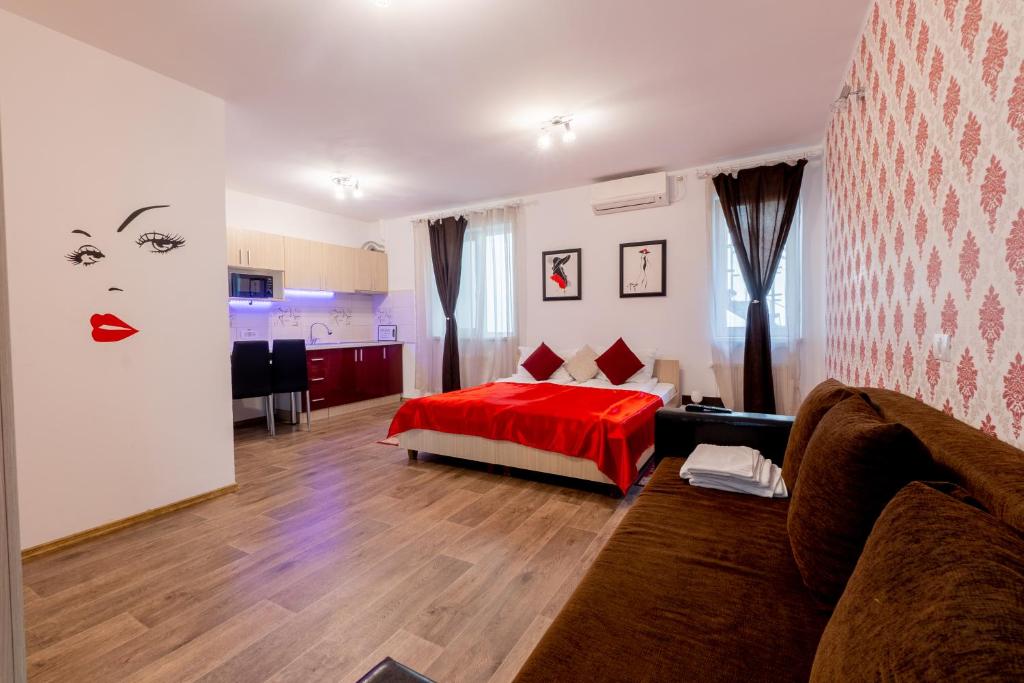 - un salon avec un lit et une couverture rouge dans l'établissement Nice & Cozy Apartments, à Timişoara