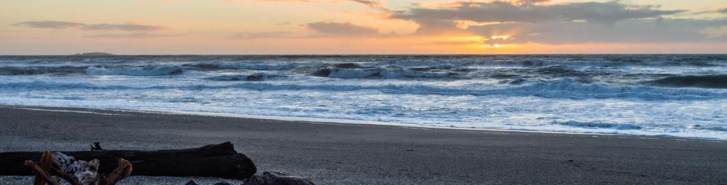 a view of the ocean with a beach with waves at Haast Beach Motel in Haast