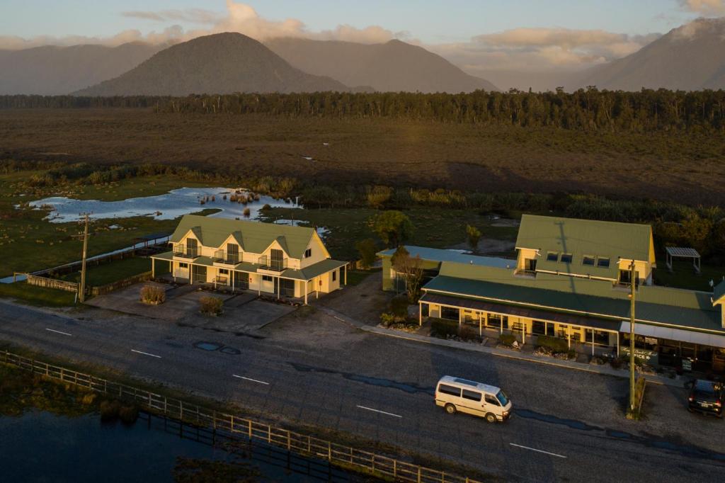 an aerial view of a building with mountains in the background at Haast Beach Motel in Haast