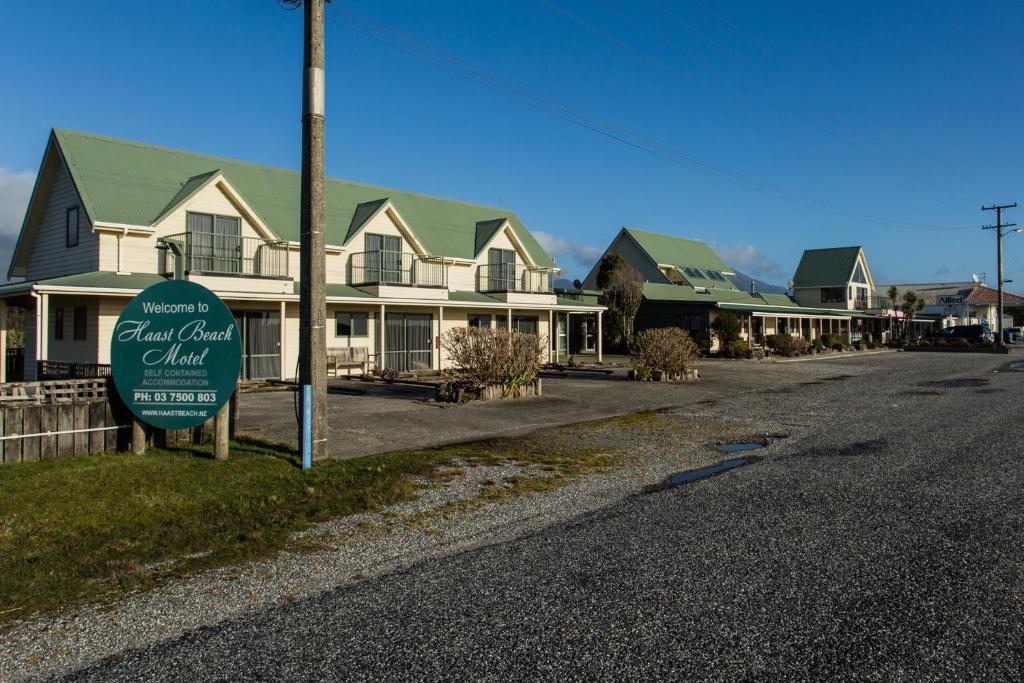a sign in front of a row of houses at Haast Beach Motel in Haast