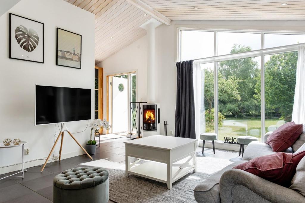 sala de estar con sofá y TV en Five-Bedroom holiday home by the river of lagan, en Knäred