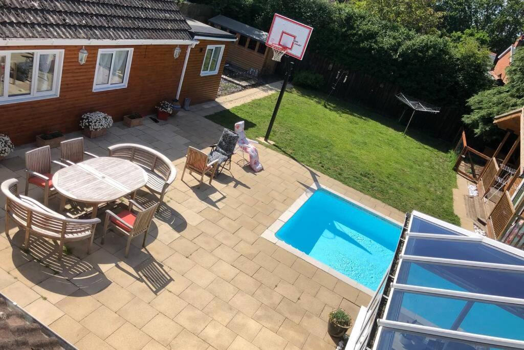 a patio with a table and chairs and a basketball hoop at Guest house in the New Forest near Paulton's Park in Cadnam