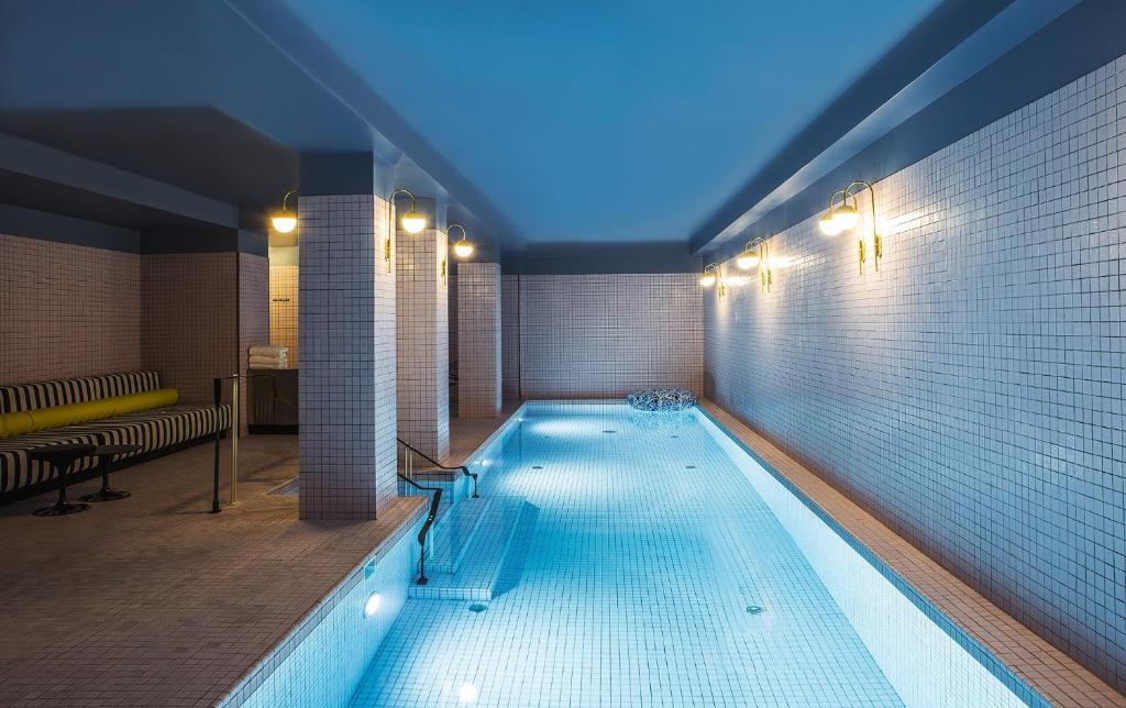 - une grande piscine dans un bâtiment à l'ouverture dans l'établissement Hôtel du Rond-point des Champs-Élysées - Esprit de France, à Paris