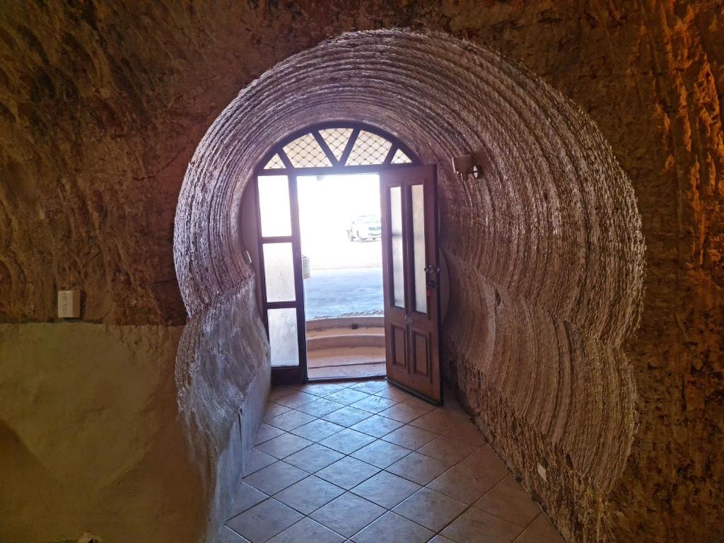 an archway with a door in a stone building at Underwood Court fresh Dugout- Hosted by Coober Pedy Accommodations in Coober Pedy