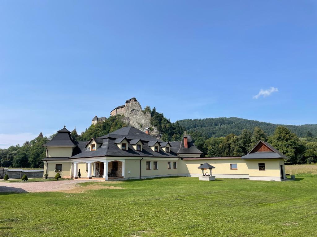 a large house with a mountain in the background at Penzión U dvoch levov in Oravský Podzámok