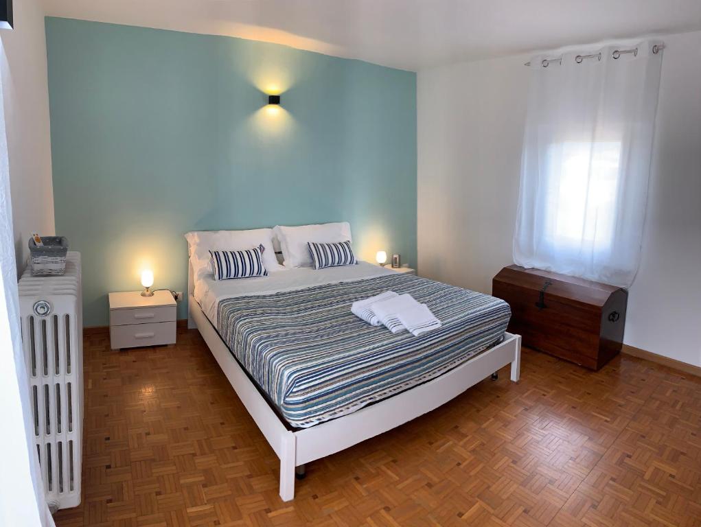 1 dormitorio con 1 cama grande y pared azul en La Spolina B&B, en Cossato