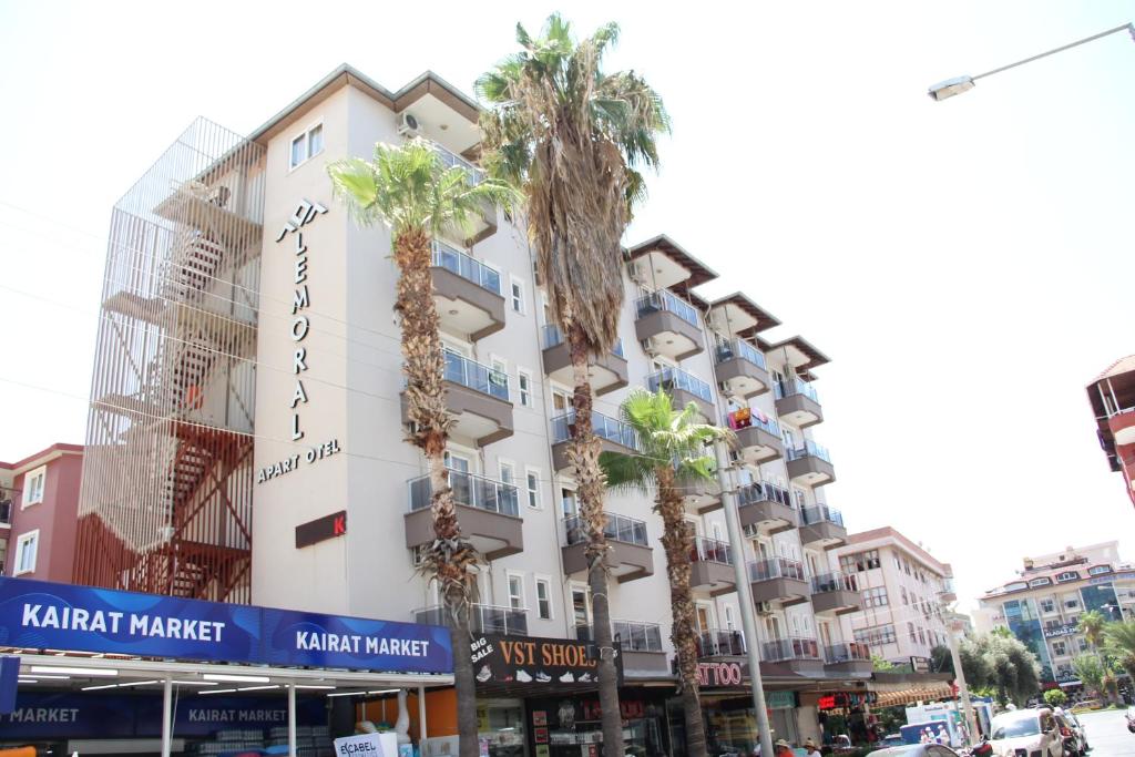 a building with palm trees in front of it at Le Moral Apart Hotel in Alanya