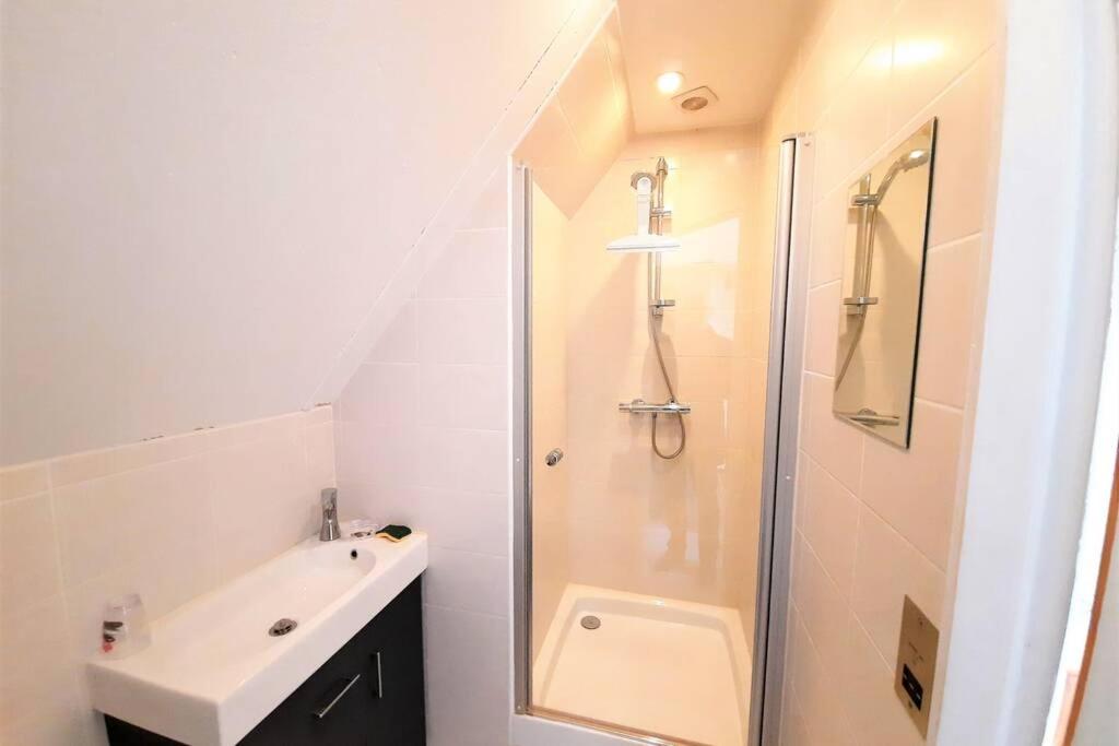 a white bathroom with a shower and a sink at Iris, les Gîtes de Carlux in Carlux