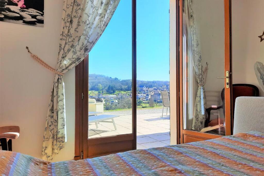 a bedroom with a bed and a sliding glass door at Iris, les Gîtes de Carlux in Carlux