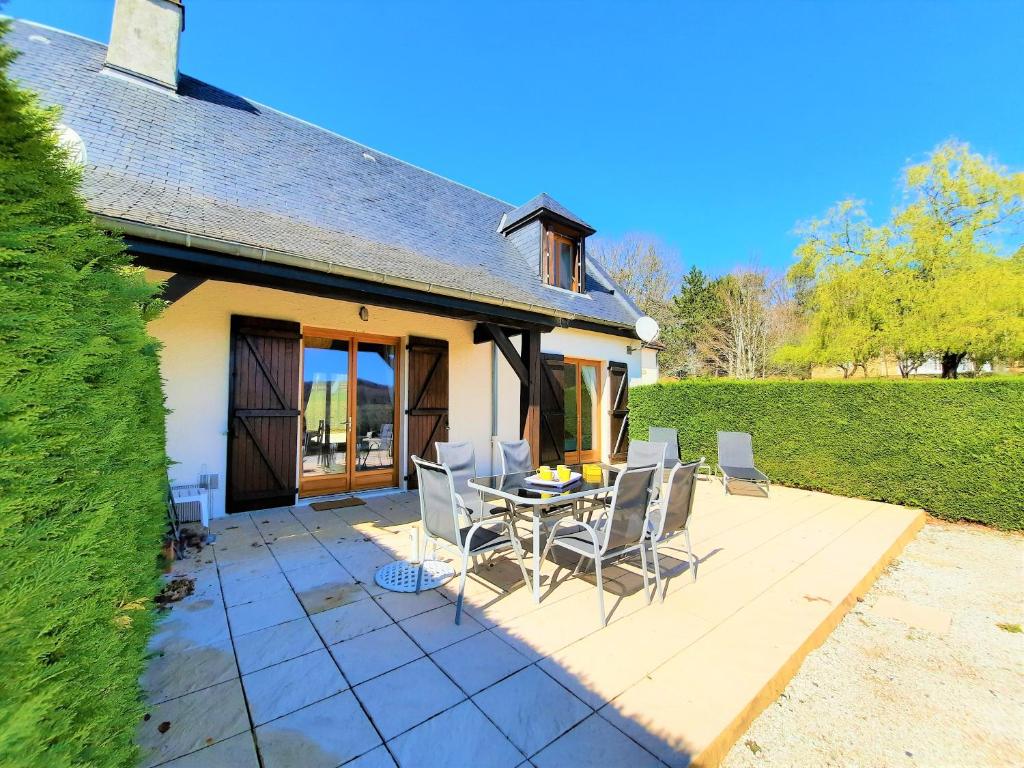 a patio with a table and chairs in front of a house at Iris, les Gîtes de Carlux in Carlux
