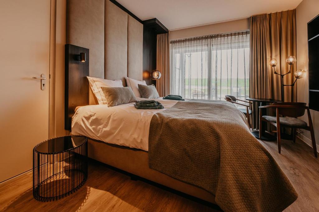 una camera da letto con un grande letto con una grande finestra di Residence Oude Haven room with terrace a Colijnsplaat