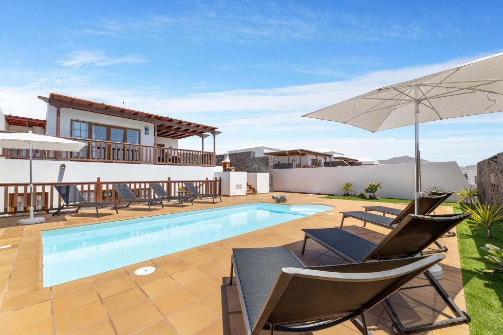 a villa with a swimming pool and patio furniture at Lanzarote Villa Vista Lobos 47 in Playa Blanca