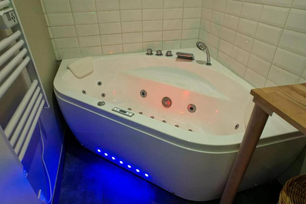 a bath tub in a bathroom with a blue floor at Le Petit Pèlerin in Ammerschwihr