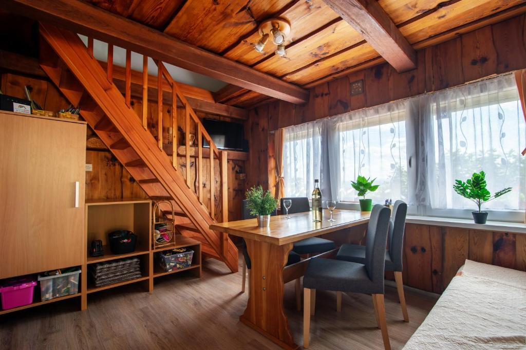 ein Esszimmer mit einem Holztisch und einer Treppe in der Unterkunft Apartma PEPI in Rogaška Slatina