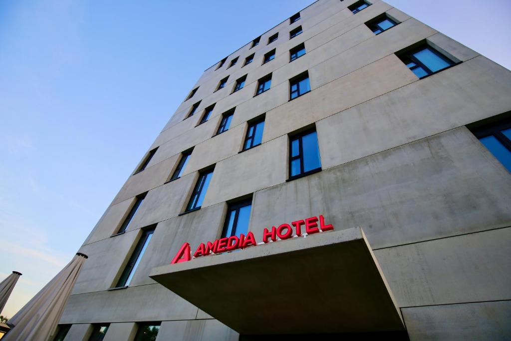 un bâtiment angulaire avec un panneau rouge sur lui dans l'établissement Amedia Lustenau, Trademark Collection by Wyndham, à Lustenau