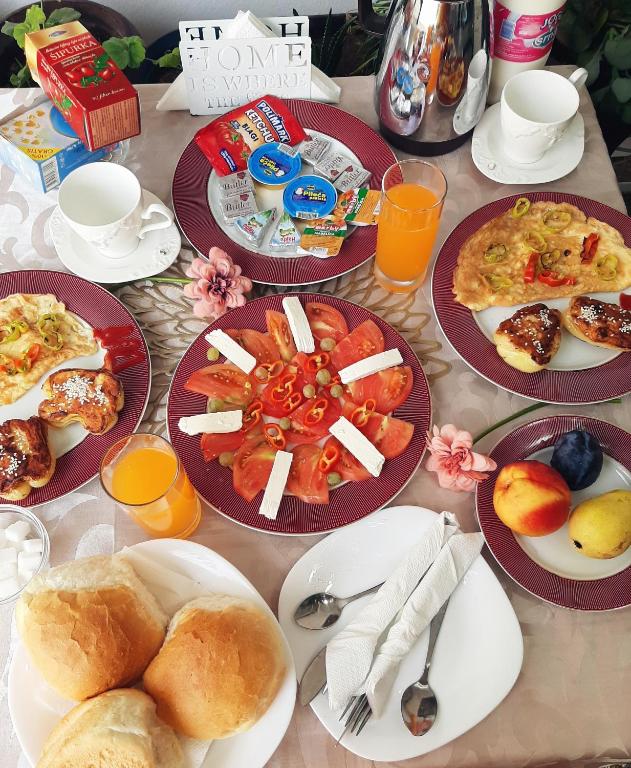 a table with plates of breakfast foods and drinks at Guesthouse DONA in Ulcinj