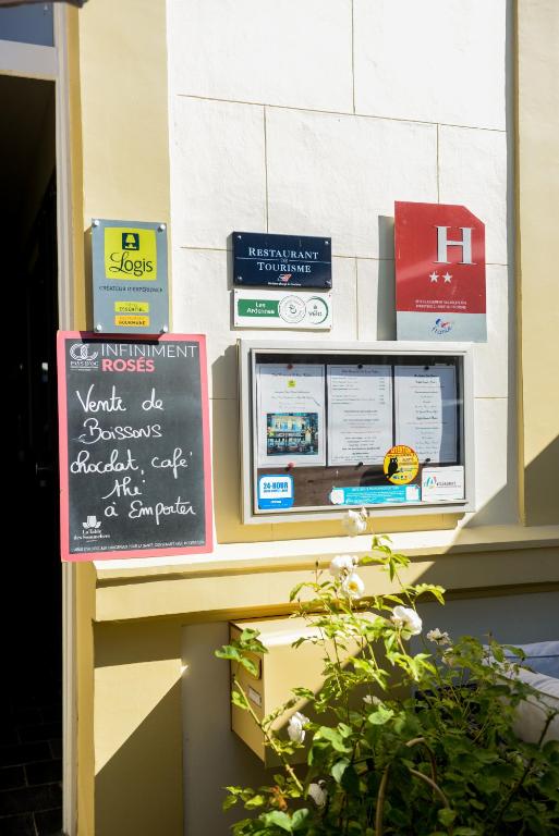 a sign on the side of a building with a menu at Logis Le Saint Hubert in Haybes