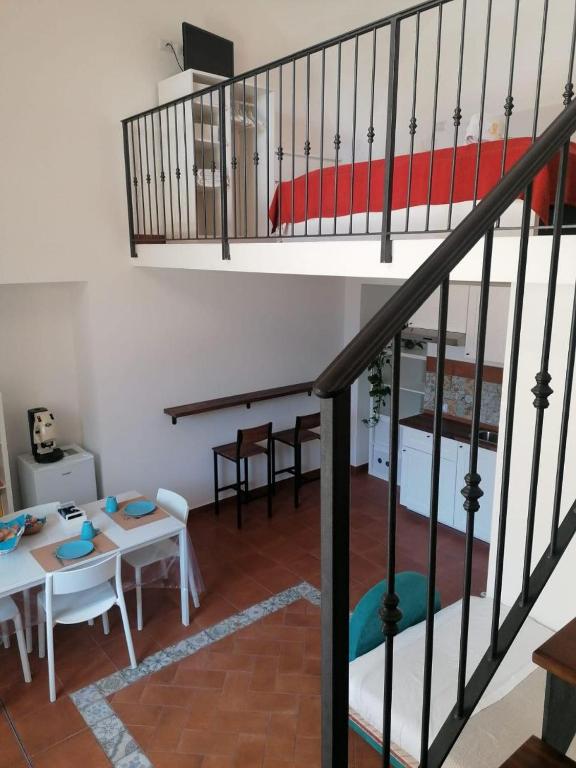 ein Wohnzimmer mit Treppe und ein Esszimmer in der Unterkunft Casetta Russo in Meta