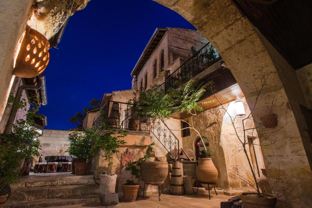 an alley with potted plants and a building at night at Kirkit Hotel in Avanos