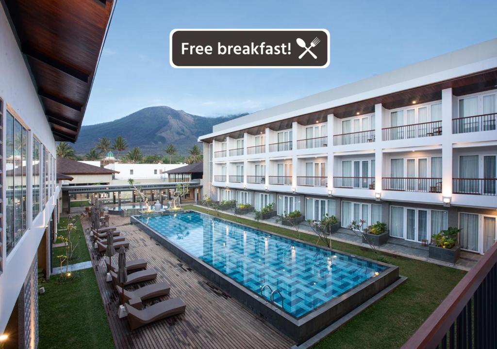 a hotel with a swimming pool in front of a building at Hotel Santika Garut in Garut