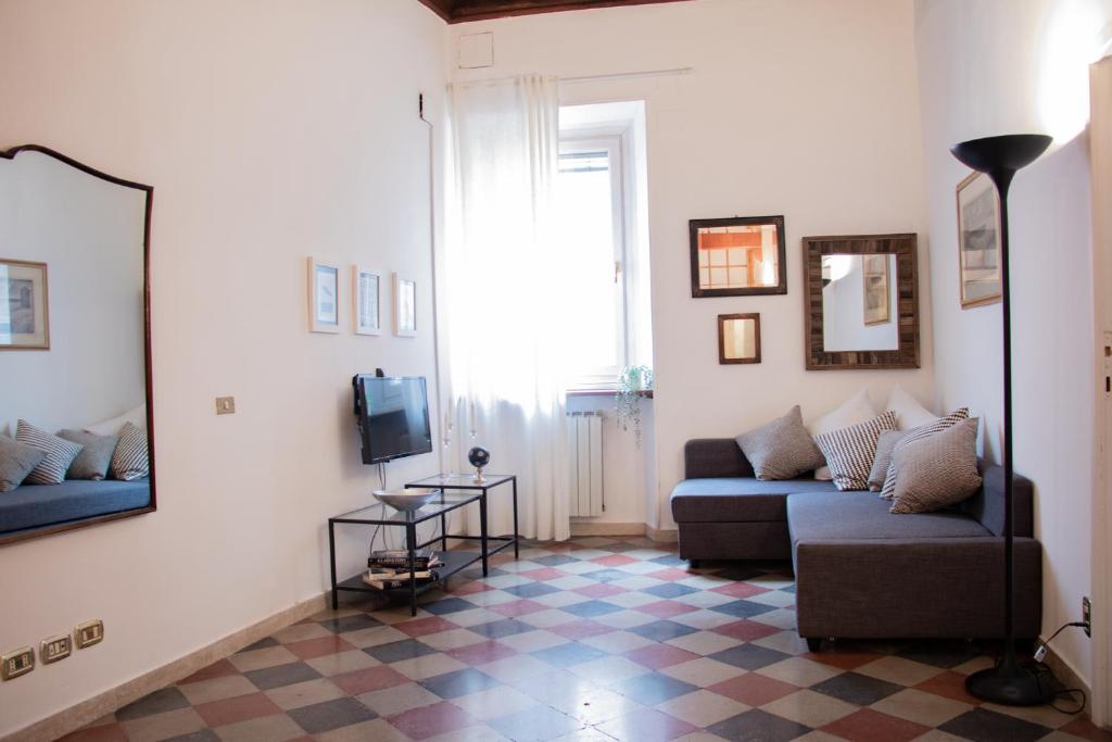 The Best Rent - Piazza di Firenze Apartment في روما: غرفة معيشة مع أريكة وتلفزيون