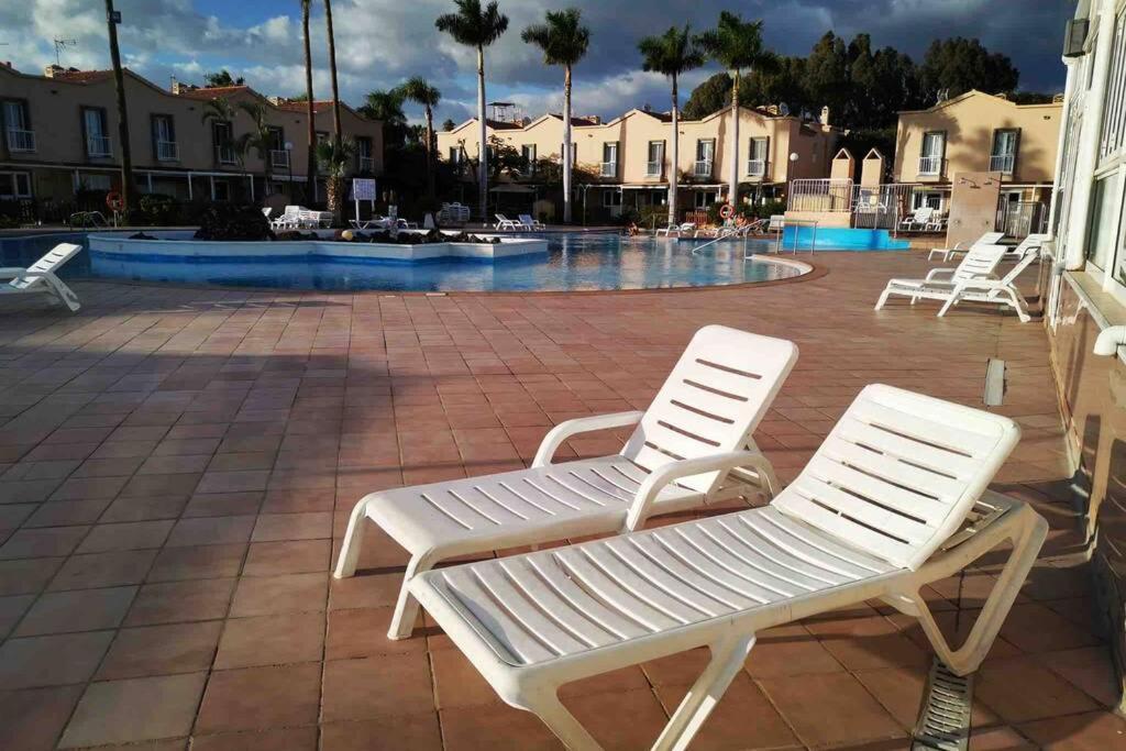 dwa białe krzesła siedzące na patio z basenem w obiekcie GLAMOUR MASPALOMAS - near MELONERAS w mieście San Bartolomé